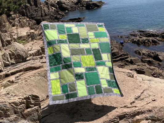 Green and grey Slea Head quilt billowing in a breeze. 